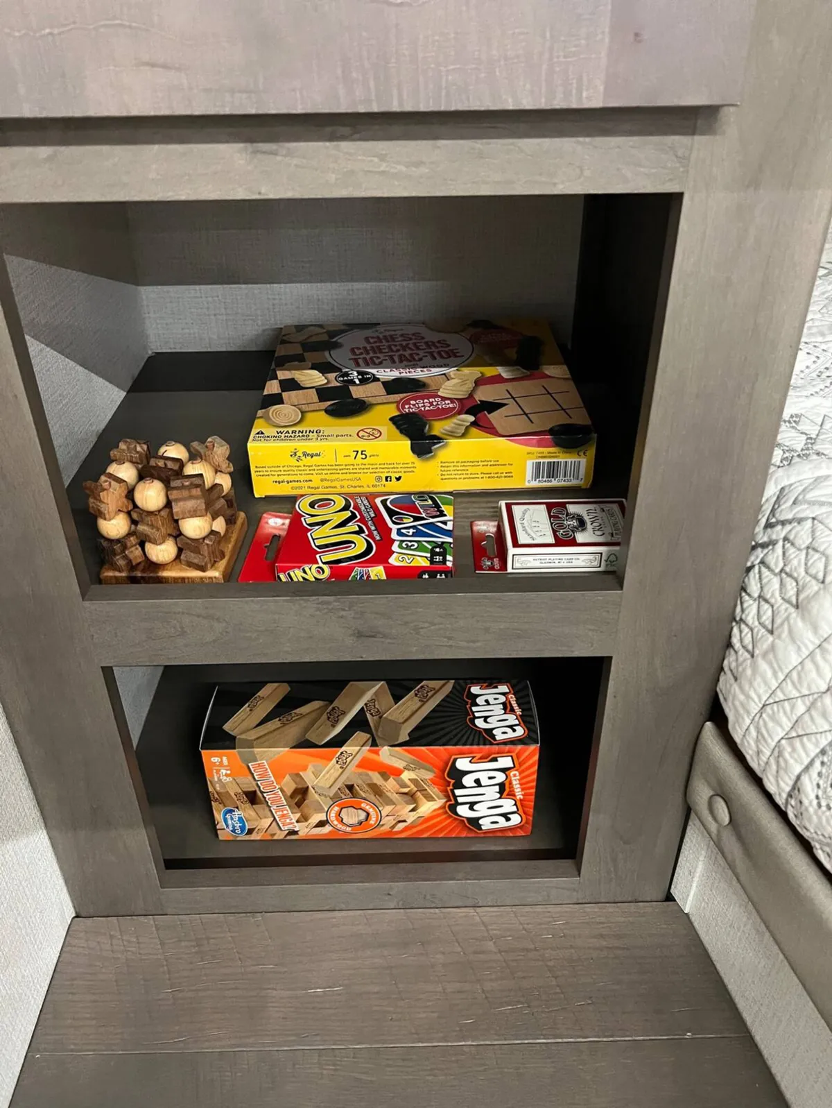 A close-up shot of wooden game pieces and board games on a table, evoking memories of playful evenings and shared stories. The focus is on the hands-on, interactive aspect of the lounge space.